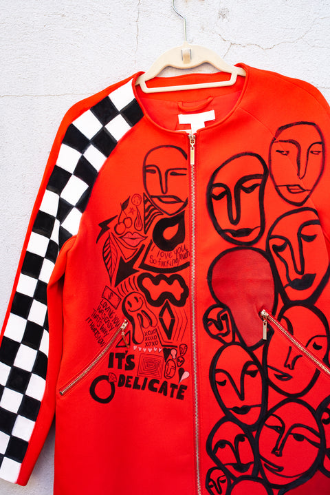 Upcycled red jacket with hand-painted graffiti detail.