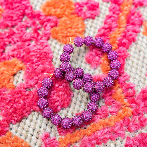 Purple glitter hoop earrings.