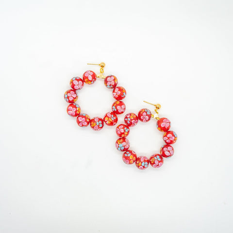 Red beaded hoop earrings with flower print.