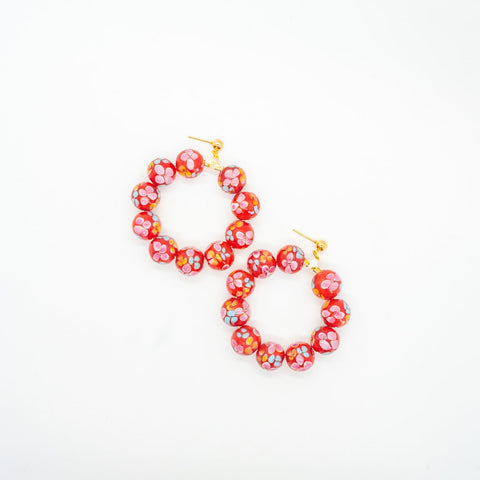 Red beaded hoop earrings with flower print.