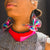Woman wearing large rainbow butterfly earrings.